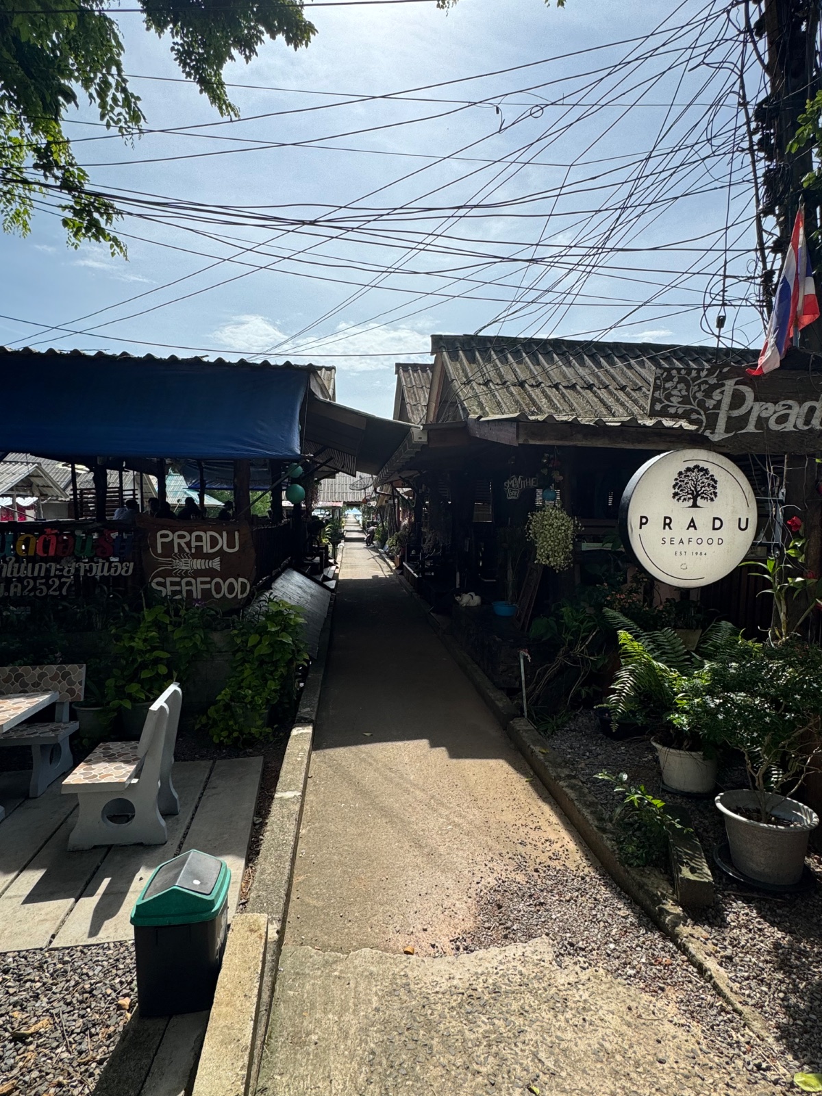Ruelle du village de pêcheurs de Koh Yao Noi avec l'enseigne du restaurant Pradu Seafood fondé en 1984