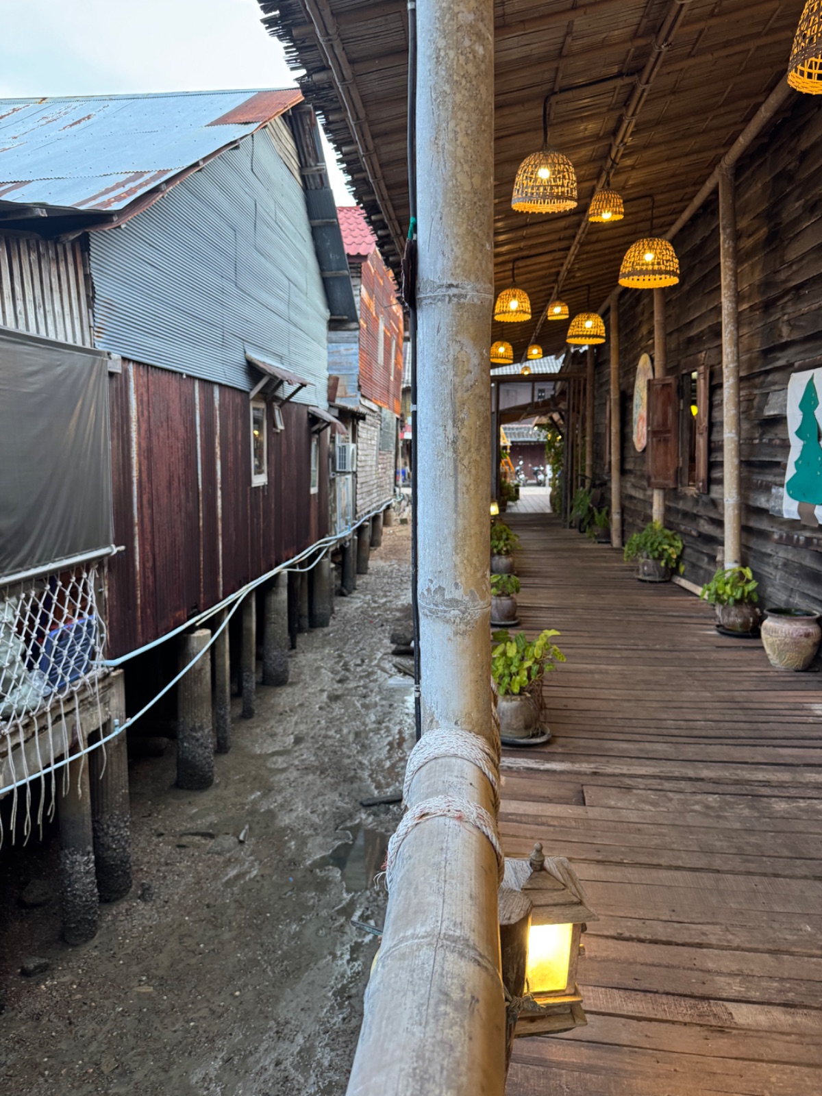Terrasse en bois sur pilotis d'un restaurant de Lanta Old Town avec ses lampions en osier, maisons sur pilotis en contrebas