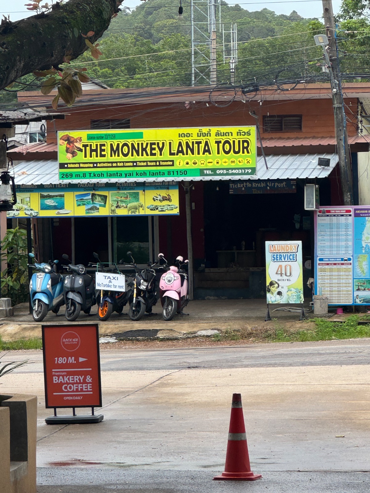 Devanture jaune de The Monkey Lanta Tour à Koh Lanta, location de scooters, tickets de bateau et laverie