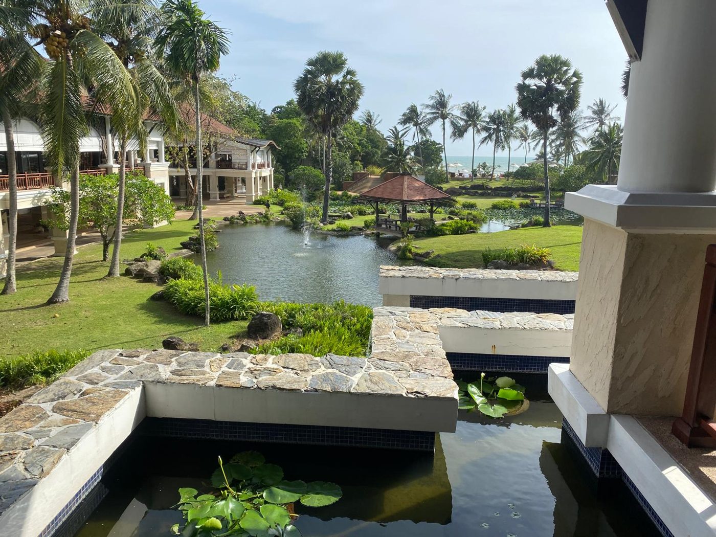 Jardin avec bassins, fontaine et palmiers du resort à Koh Lanta, face à la mer